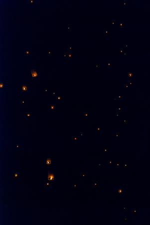 Light up lanterns flying to the sky at night during Loy Krathong festival in Chiang Mai, Thailandの写真素材