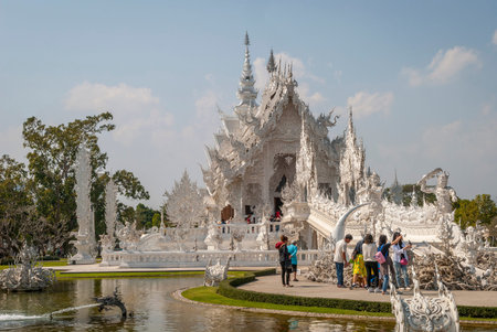 Chiang Rai, Thailand - Feb 2016: Tourists visiting famous Chiang Rai White Temple - Wat Rong Khun on a sunny day.のeditorial素材