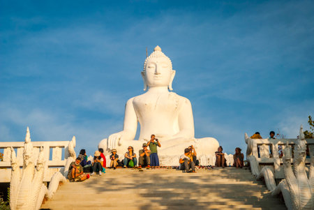 Pai, Thailand - Jan 2016: Group of people sitting next to white Buddha in Pai, Thailandのeditorial素材