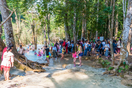 Luang Prabang, Laos - Feb 2016: Crowd of people visiting Kuang Si waterfalls and getting into the water. Waterfalls one of the biggest attractions in the areaのeditorial素材