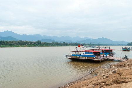 Luang Prabang, Laos - Feb 2016: Local ferry raft loading motorbike to be transferred over the Mekong river, Laosのeditorial素材