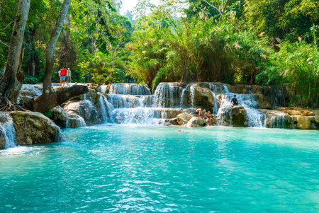 Luang Prabang, Laos - Feb 2016: People swimming in the water and visiting Kuang Si waterfalls, one of the biggest attractions in the areaのeditorial素材