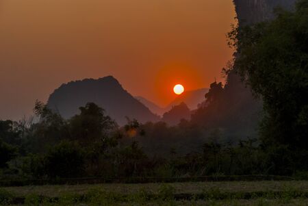 Beautiful karst mountains landscape surrounding Vang Vieng, Laos, in sunsetの写真素材