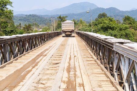 Heavy truck driving over wooden bridge, Laosの写真素材