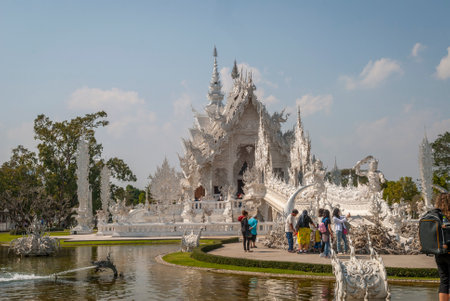 Chiang Rai, Thailand - Feb 2016: Tourists visiting famous Chiang Rai White Temple - Wat Rong Khun on a sunny day.のeditorial素材