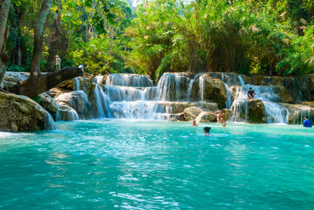 Luang Prabang, Laos - Feb 2016: People swimming in the water and visiting Kuang Si waterfalls, one of the biggest attractions in the areaのeditorial素材