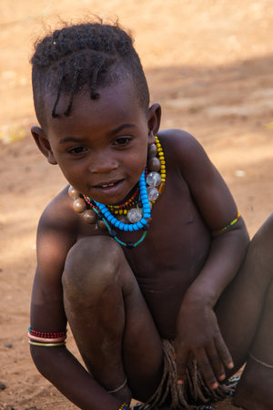 Turmi, Ethiopia - Nov 2018: Young Hamer tribe kid playing next to the house, Omo valleyのeditorial素材