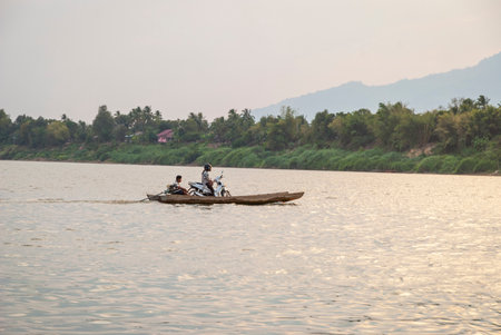 Muang Champassak, Laos - Feb 2016: Motorbike on a boat crossing Mekong river, Laosのeditorial素材