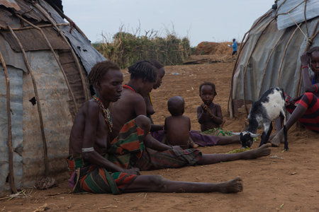 Omorate, Ethiopia - Nov 2018: Women and kids sitting outside of their houses in the village. Omo valleyのeditorial素材
