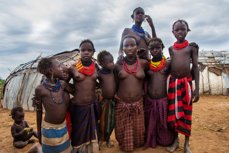 Omorate, Ethiopia - Nov 2018: Dasanech tribe women and kids standing proudly wearing traditional clothes and necklacesのeditorial素材