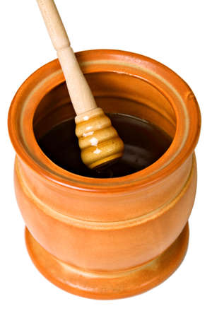 Ceramic jar with honey and wooden stick, isolated on whiteの写真素材