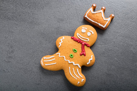 Christmas homemade gingerbread man with crown with coloured icing on gray table. Close up view.