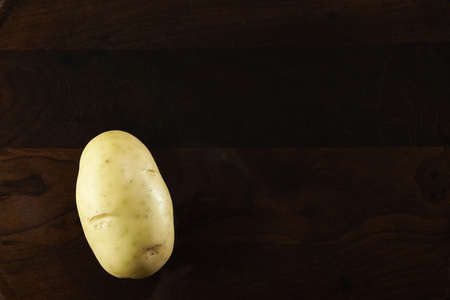 potato isolated on a rustic wooden backgroundの写真素材