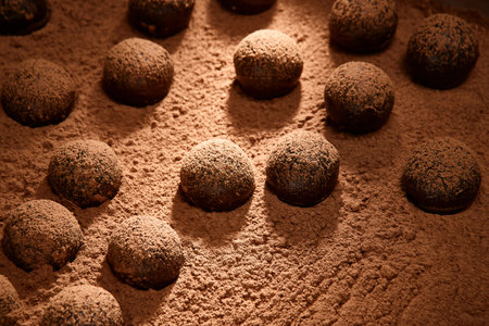 Bitter chocolate brigadeiros getting chocolate powder layer