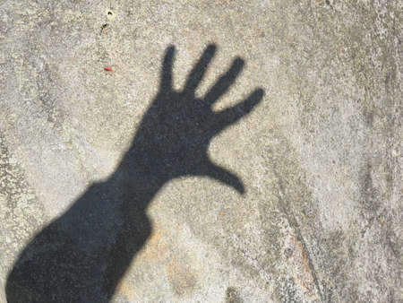 Shadow of a photographer's hand on a gray stoneの写真素材