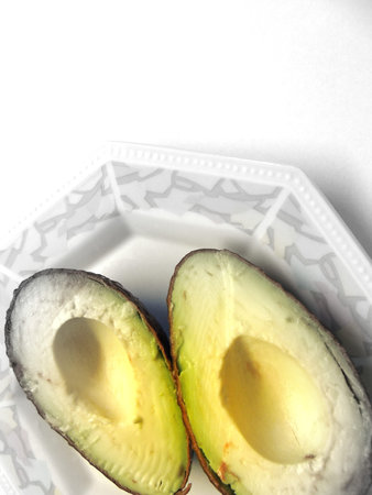 Avocado halfs in porcelain plateの写真素材