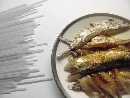 uncooked spaghetti and anchovy in white backgroundの写真素材