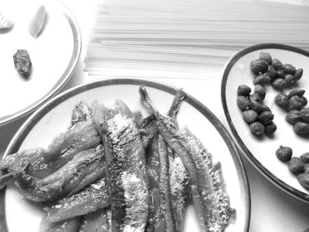 uncooked spaghetti, anchovy, garlic, chilli pepper and caper in white backgroundの写真素材