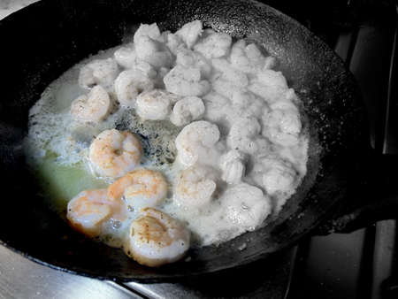 fresh shrimps being cooked in a fryin panの写真素材