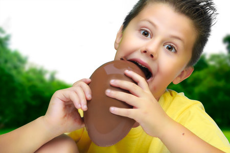 boy eating delicious chocolate eggs, celebrating Easter