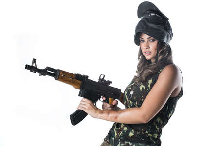 Woman in military uniform with a gunの写真素材