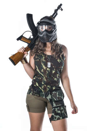 Woman in military uniform with a gunの写真素材