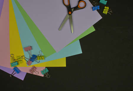 Back to school, education concept, school accessories. Multicolor paper, paper clips and scissors on marble background with copy space. Flat lay, top view.の写真素材