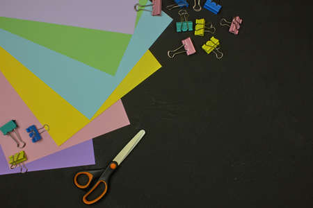 Back to school, education concept, school accessories. Multicolor paper, paper clips and scissors on marble background with copy space. Flat lay, top view.の写真素材