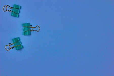 A few blue paper clips on a colorful background with copy space for textの写真素材