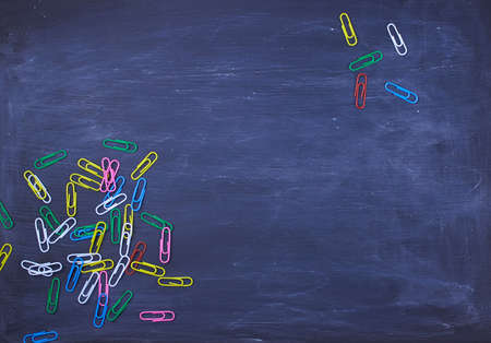 Multicolored paper clips on a dark blue background with copy space for textの写真素材