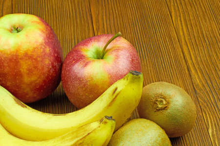 Close up view of red apples, bananas and kiwi on wooden background. Still life of fresh fruits.の写真素材