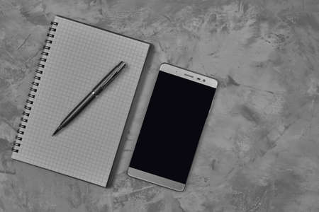 White notepad paper notepad with pen and phone on wooden background, closeupの写真素材