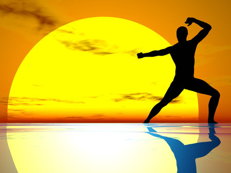 Man in fighting position ailhouetted against a sunsetの写真素材