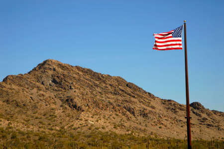 Dramatic desert mountains with an American flag flyingの写真素材
