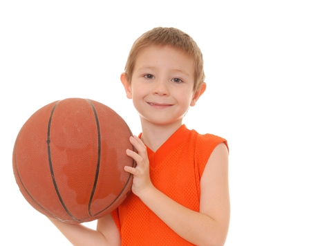 Young boy playing with a basketball isolated on whiteの写真素材