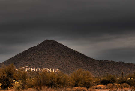 Large sign on a desert mountain pointing the direction to Phoenixの写真素材