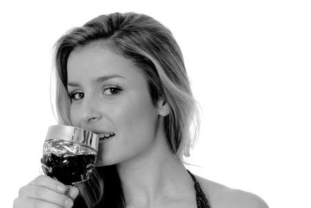 Lovely young blond girl drinking from a glass of wineの写真素材