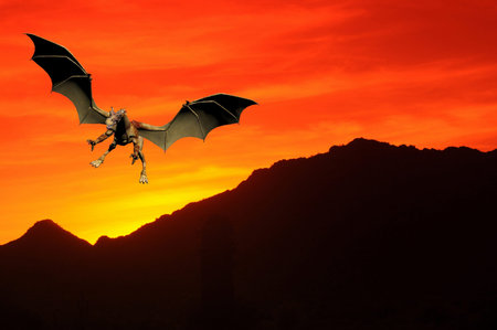 Dragon flying over desert mountains at sunsetの写真素材
