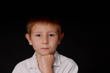 Portrait of a Young boy isolated on blackの写真素材