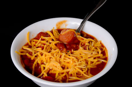 Chili with meat, hotdogs, chips, and cheese isolated on blackの写真素材
