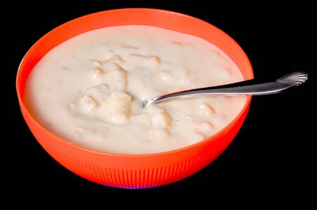 A steaming bowl of clam chowder isolated over blackの写真素材