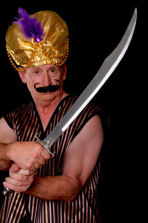 An elder sultan or shiek with a sword isolated over black