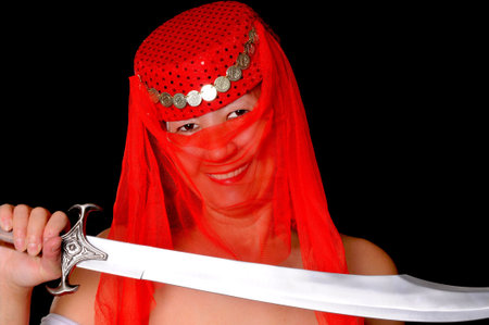 Beautiful arabian style dancer with red veil and sword