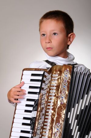 Young boy playing a 48 base accordionの写真素材