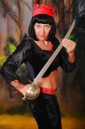 Isolated lovely and sexy young brunette dancing girl holding a swordの写真素材