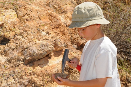 Young boy studing geology out in the fieldの写真素材