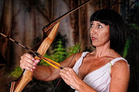 Tough brunette girl with bow and arrowの写真素材