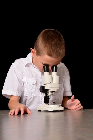 A young scientisst looking through a microscopeの写真素材