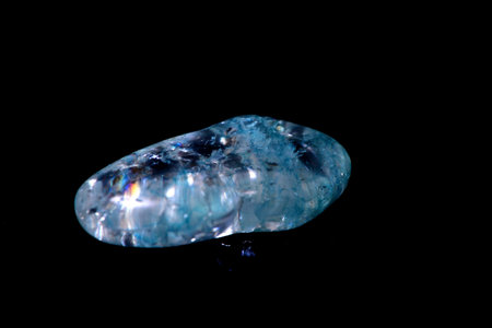 Polished aquamarine stone isolated over black background