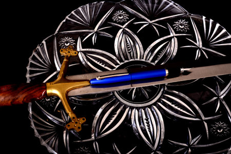 Medieval Sword and pen isolated over a black background 